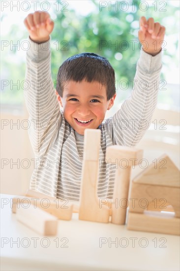 Boy (6-7) playing with toy blocks.