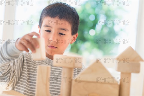 Boy (6-7) playing with toy blocks.