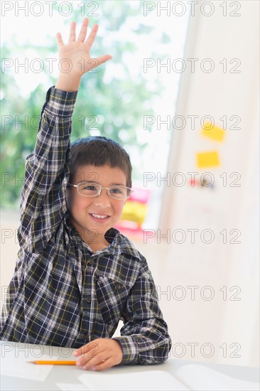 Boy (6-7) holding scale model of wind turbine.