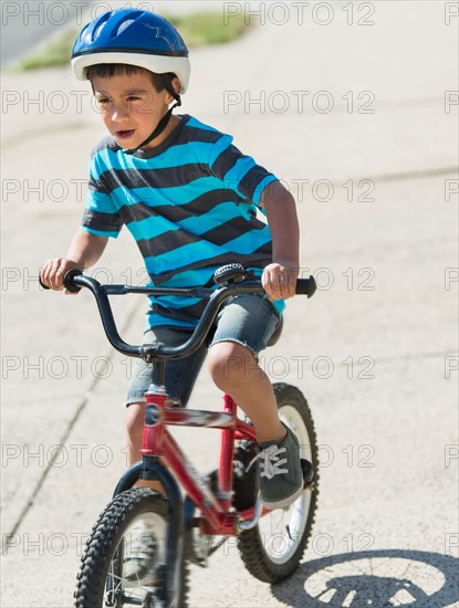 Boy (6-7) riding bicycle.