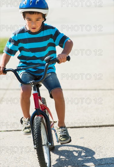 Boy (6-7) riding bicycle.