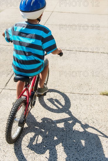 Boy (6-7) riding bicycle.