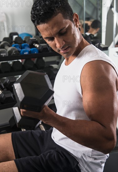 Man lifting weights in gym.