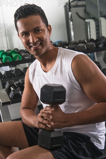 Man lifting weights in gym.