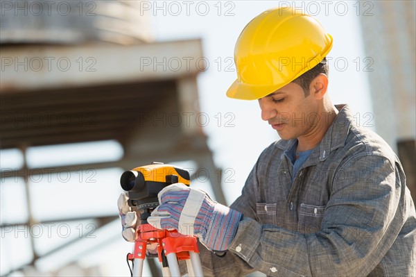 Construction worker using theodolite.