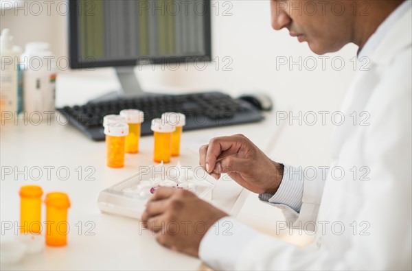 Pharmacist preparing prescription pills.