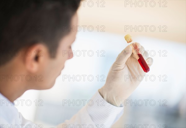 Technician holding blood sample.