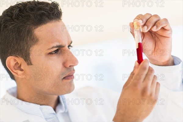 Technician examining blood sample.