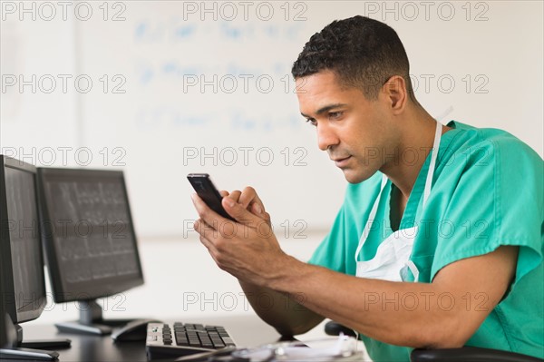 Surgeon working on computer and text messaging.