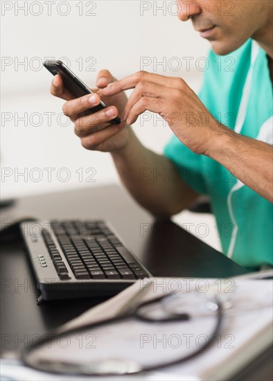 Surgeon working on computer and text messaging.