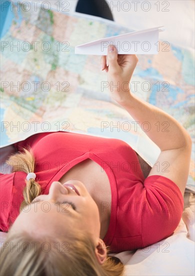 Young woman holding paper plane