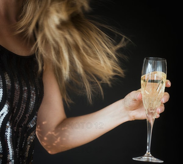 Young woman making toast with champagne