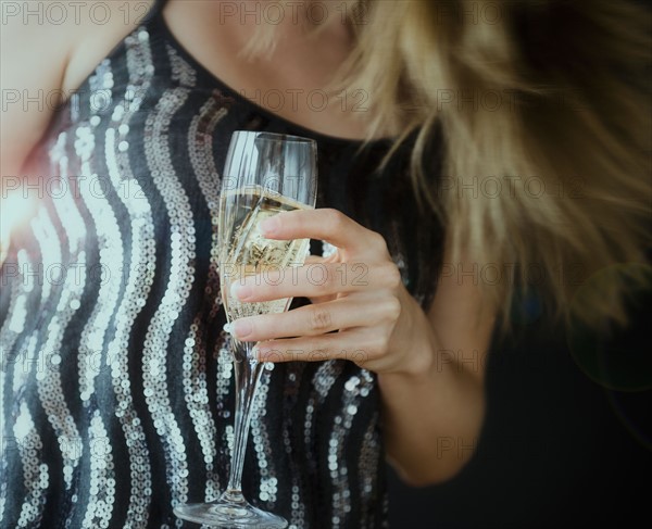 Young woman making toast with champagne