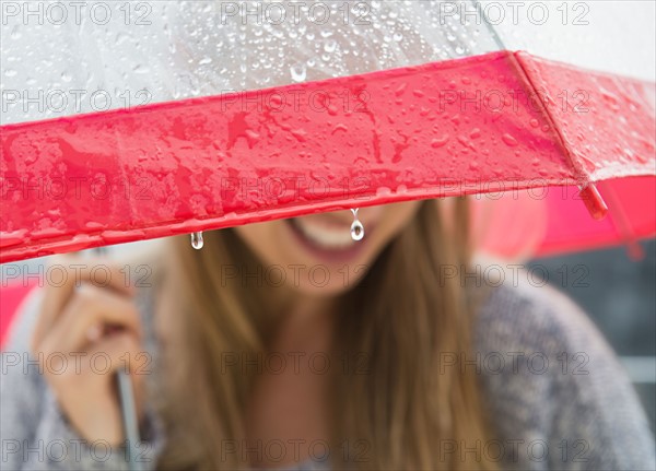 Young woman under umbrella in rain