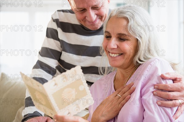 Portrait of elderly couple reading greeting card