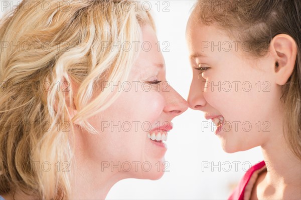 Mother and daughter (8-9 years) rubbing with noses