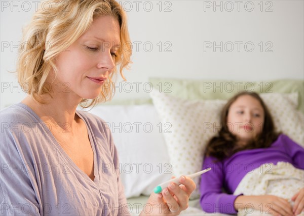 Mother checking temperature to daughter (8-9)