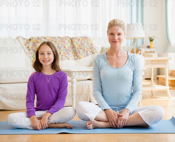 Mother and daughter (8-9) practicing yoga