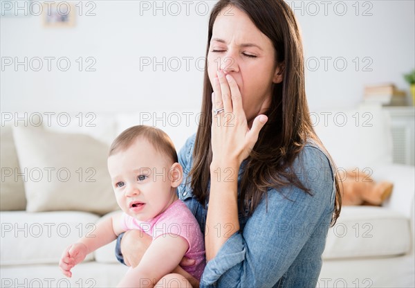 Mother with daughter (6-11 months) sitting in living room