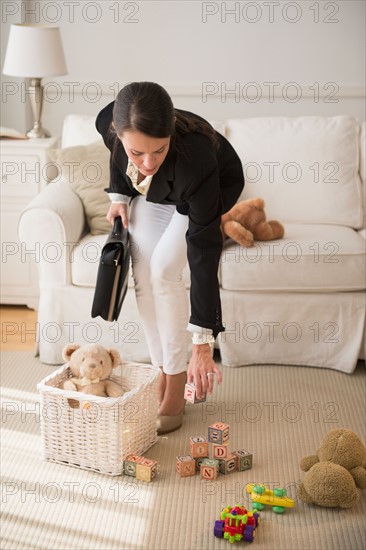 Woman is cleaning toys in living room