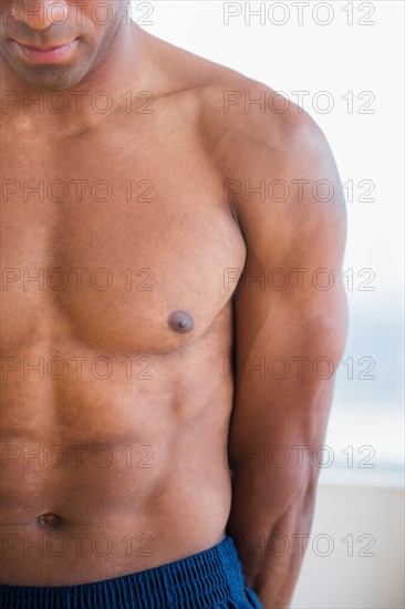 Athletic young man showing abs