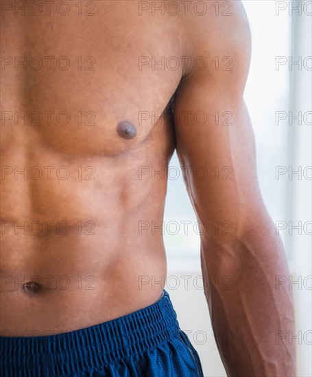 Athletic young man showing abs