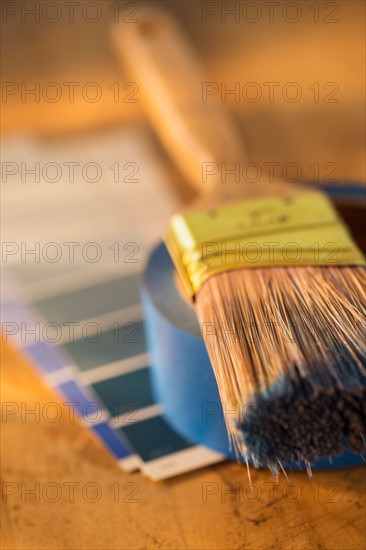 Elevated view of paintbrush, masking tape and color swatches