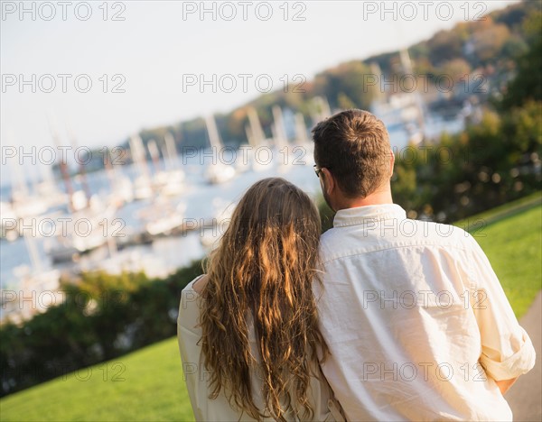 Couple walking with harbor in background