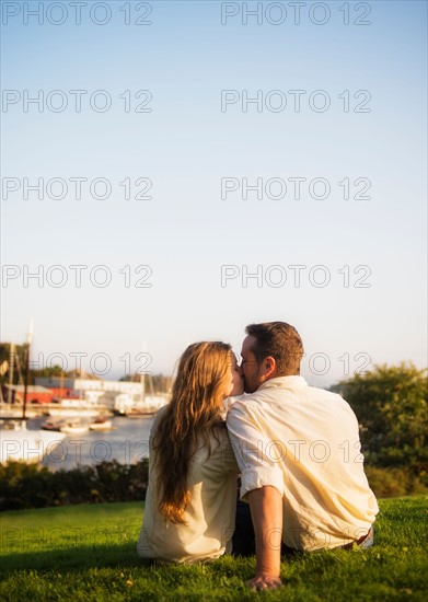 Couple kissing, harbor in background