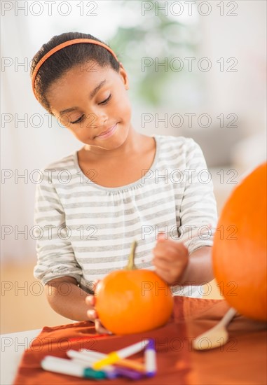 Girl (6-7) making Jack-o-lantern