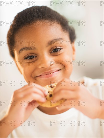 Portrait of smiling girl (6-7) eating cookie