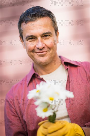 Portrait of smiling man holding flowers