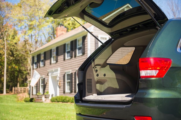 Open car trunk in front of house