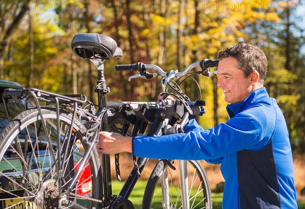 Man putting bicycle onto bike rack