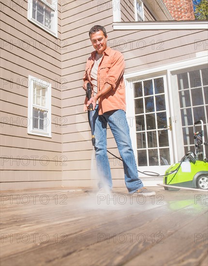 Portrait of man cleaning porch