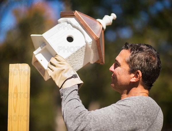 Man putting up birdhouse