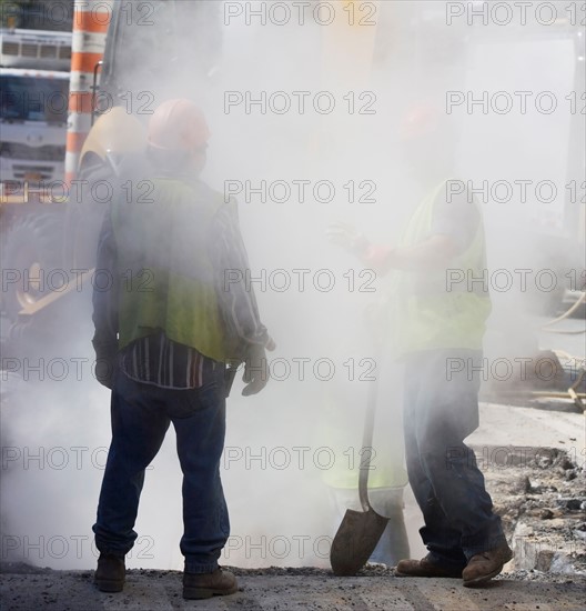 Construction workers digging hole