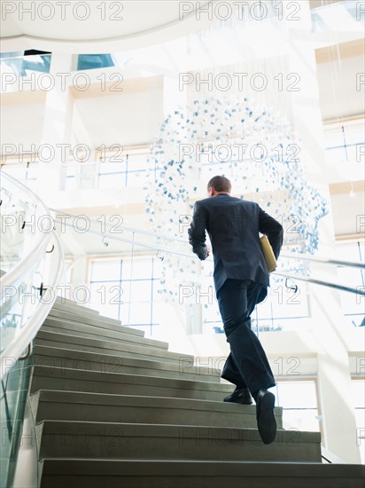 Rear view of man running up stairs