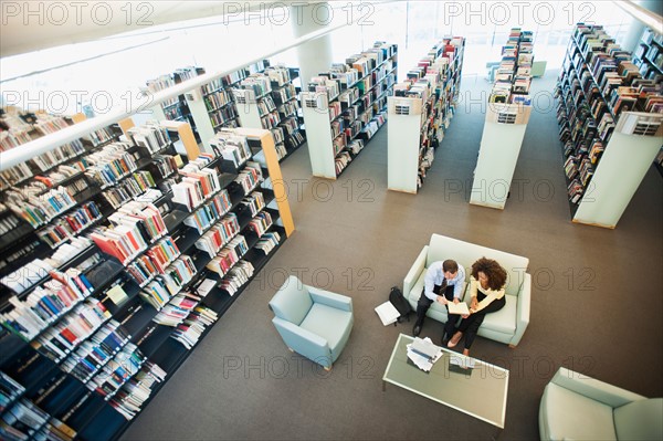 Elevated view of man and woman reading in library