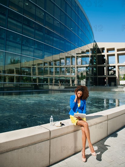 Young woman taking brake on ledge