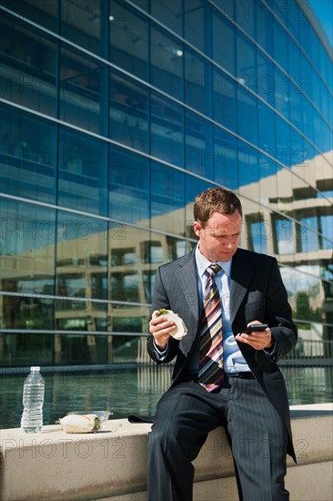 Young man taking lunch brake on ledge