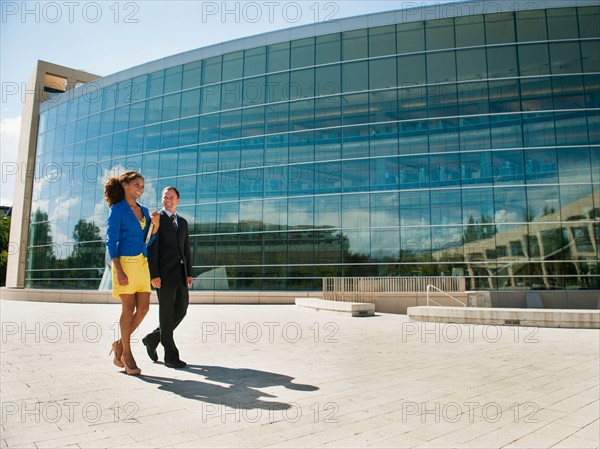 Man and woman walking outside office building