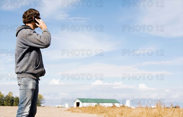 Farmer in field using cell phone