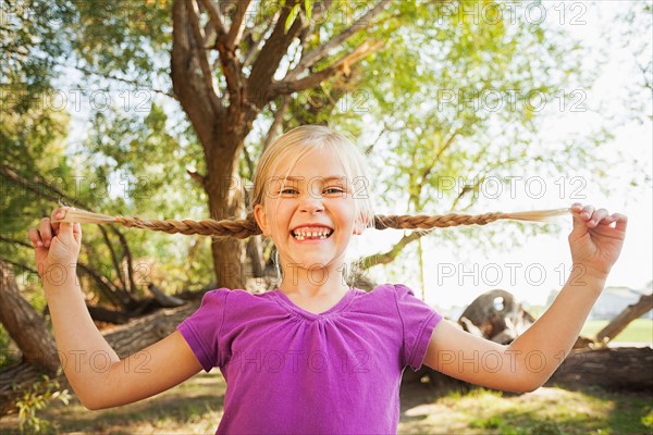 Little girl (4-5) holding out her pig tails as far as she can