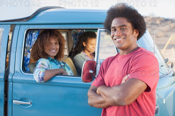 Man in foreground with friends during their road trip