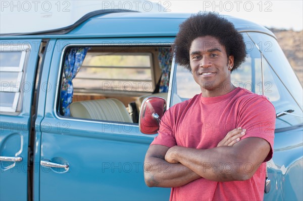 Man in front of his mini van during road trip