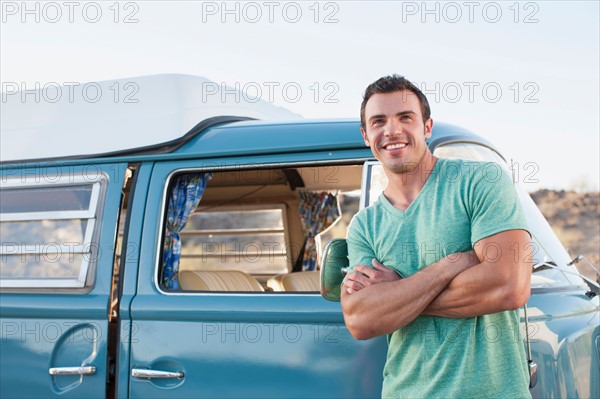 Man in front of his mini van during road trip