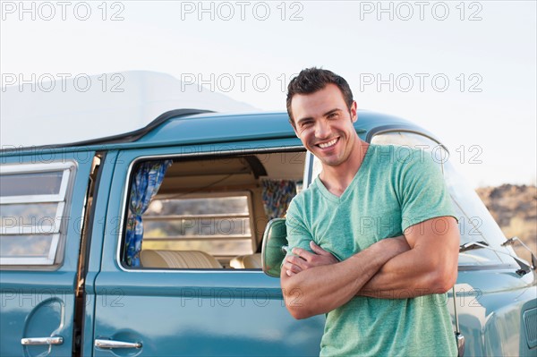 Man in front of his mini van during road trip