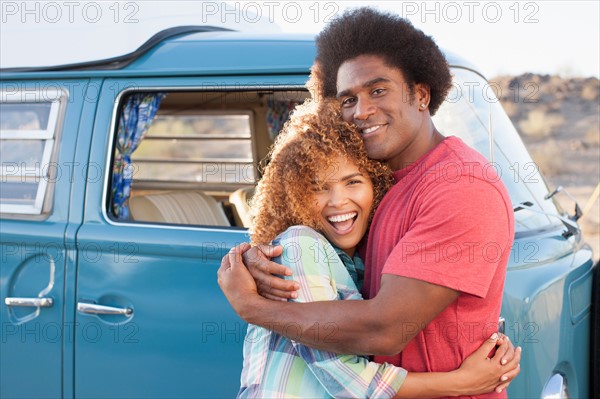 Couple in front of mini van during road trip