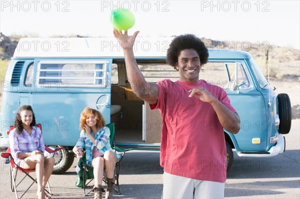 Smiling man and women in front of van